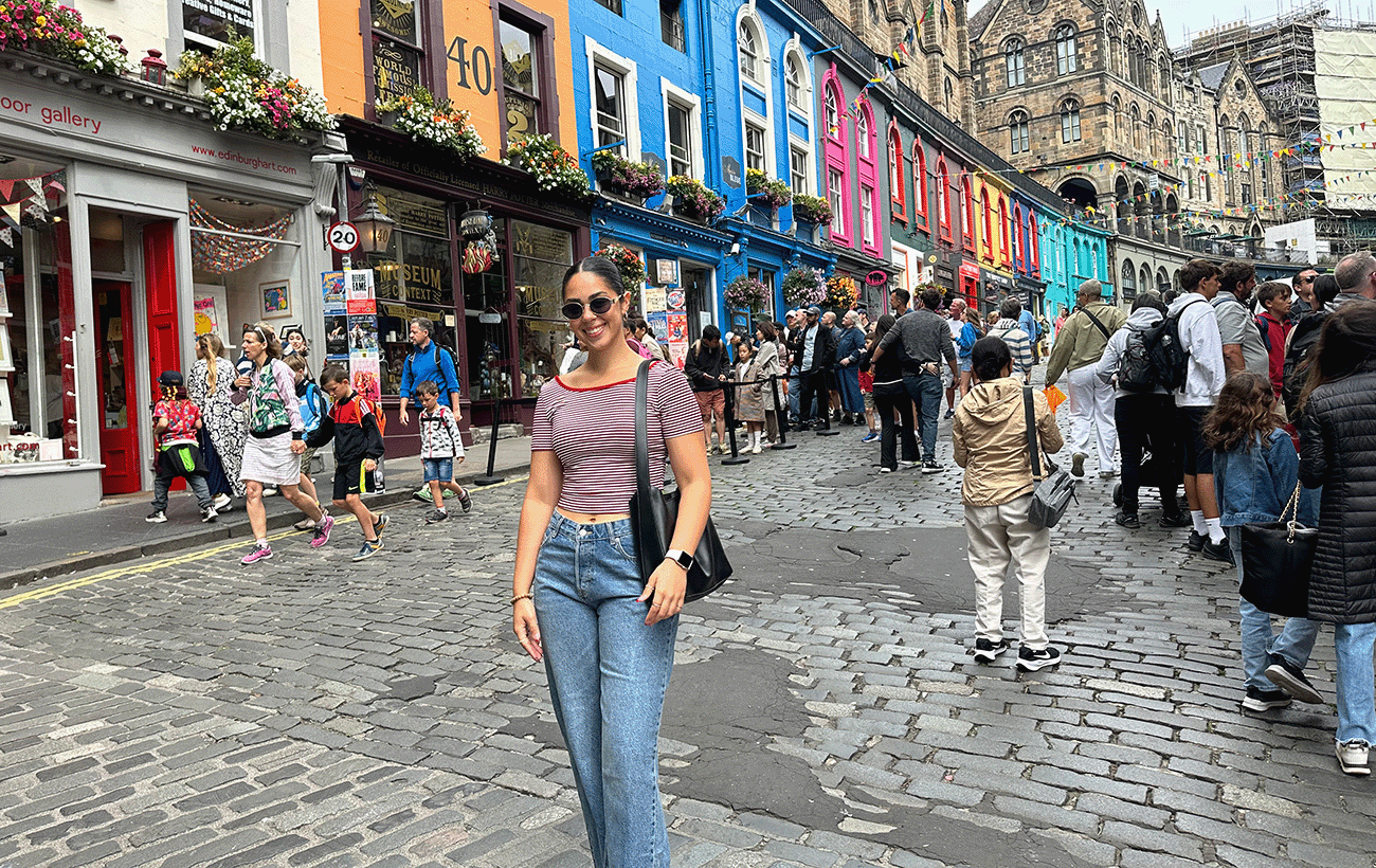ChloeAnna Rossi standing in front of colorful buildings in Edinburgh, Scotland